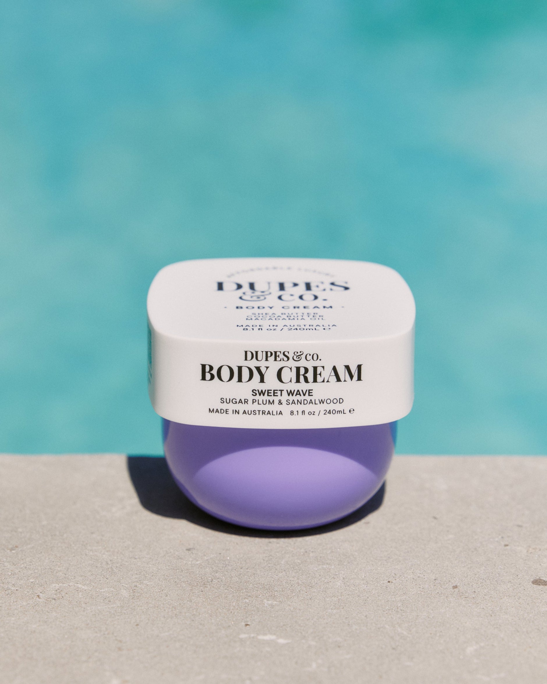 Jar of Dupes & Co. body cream with a blue background